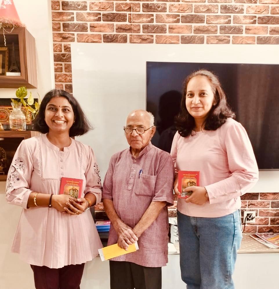 Prof. Gupta gifting two students copies of the Bhagavad Gita at his home.