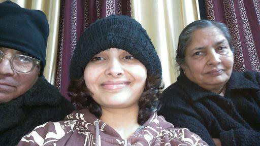 An old family photograph of Prof. Gupta on a sofa with three children.